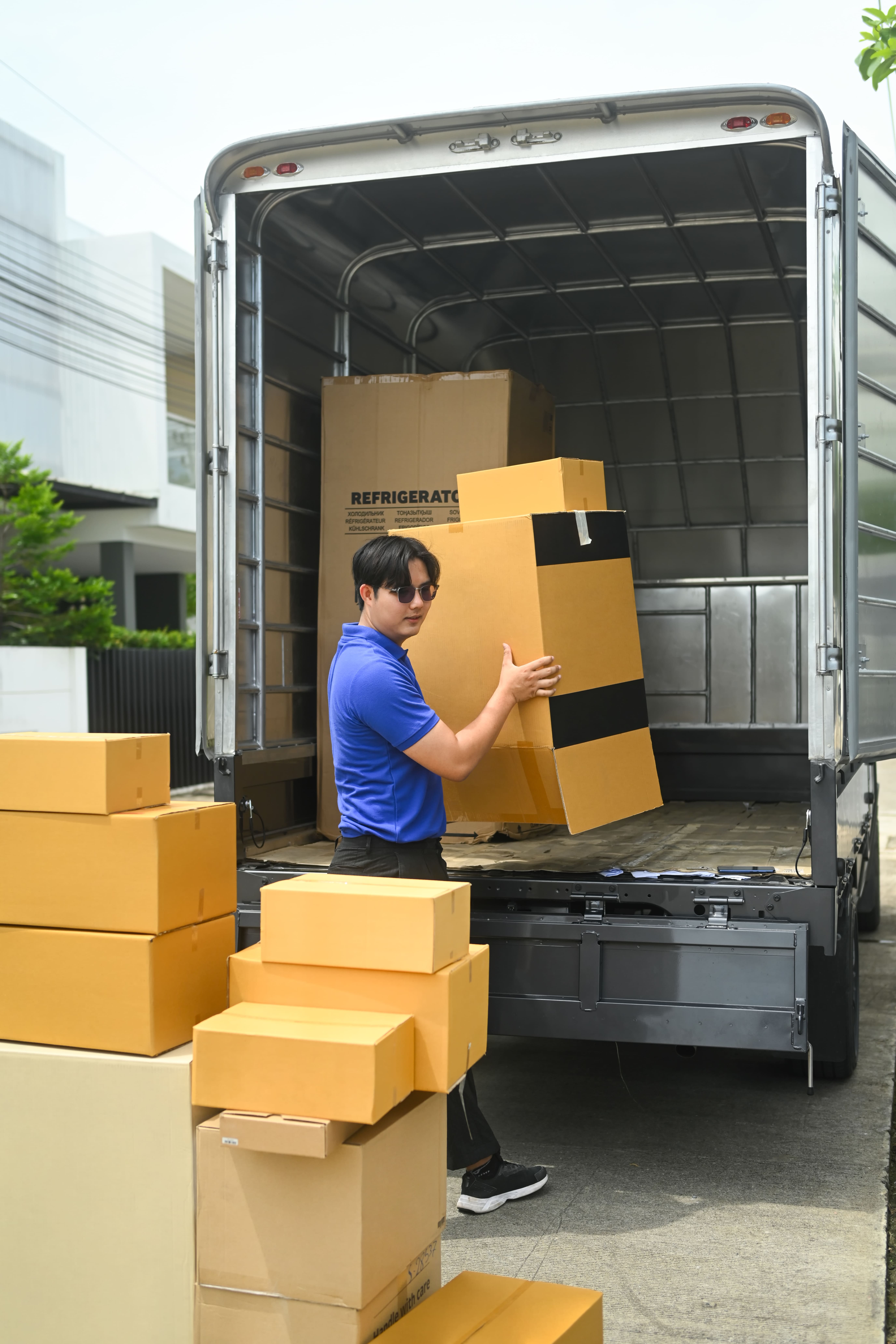 delivery-man-in-uniform-unloading-cardboard-boxes-2024-12-05-21-05-41-utc (1)